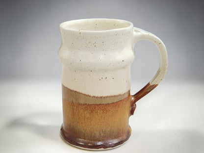 Handmade stoneware beer stein with earthy brown base and cream glazed top