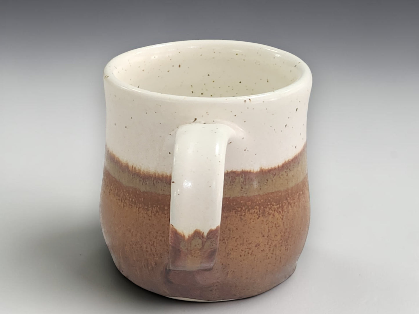 Brown and cream pottery mug with comfortable handle