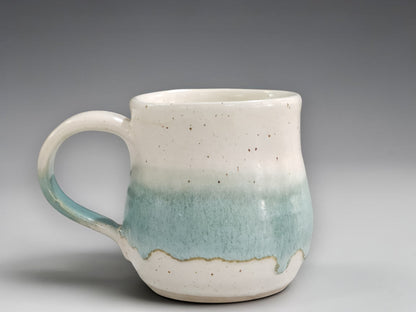 Handmade pottery mug in speckled cream and green glaze