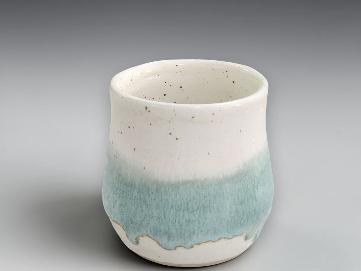 Speckled cream pottery mug with rounded belly shape