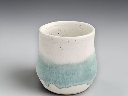 Speckled cream pottery mug with rounded belly shape