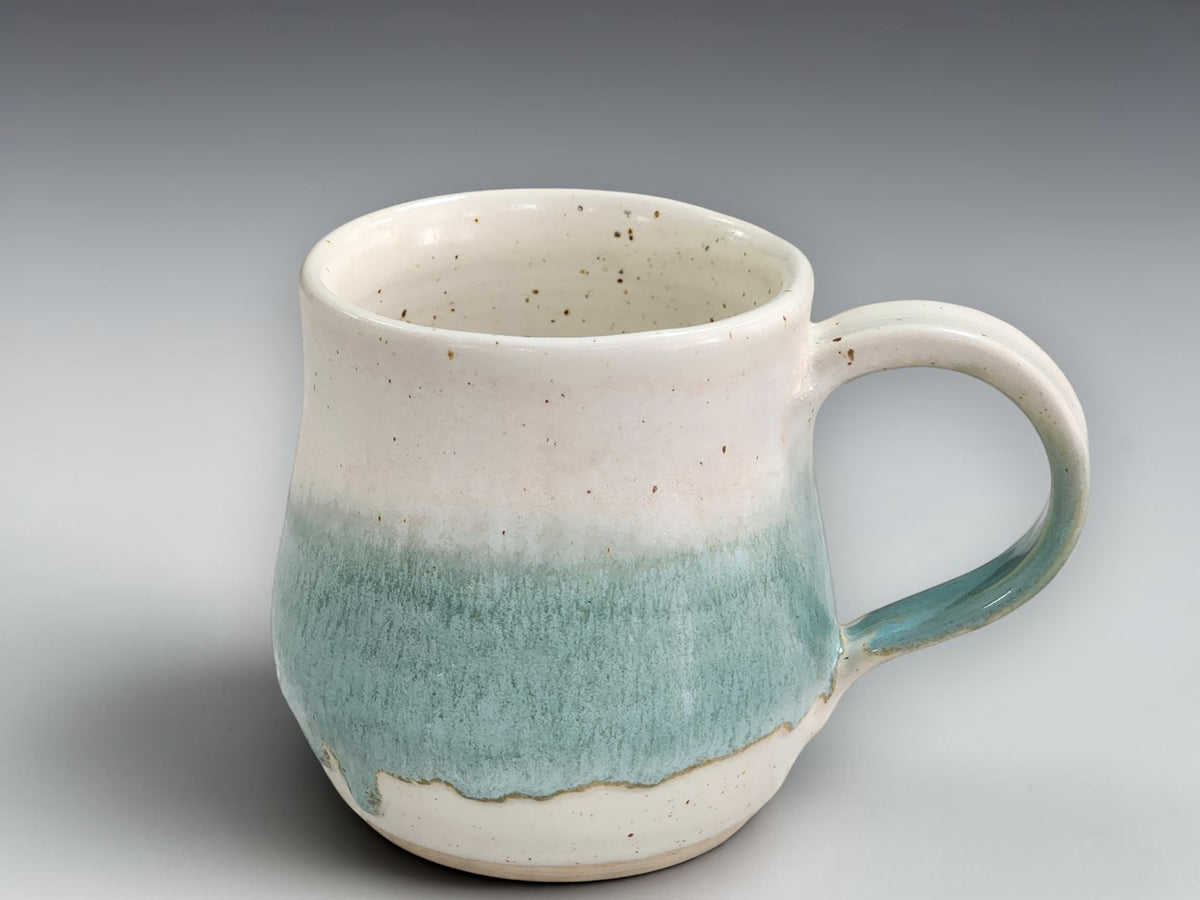 Handmade tea mug with cream and green glaze detail