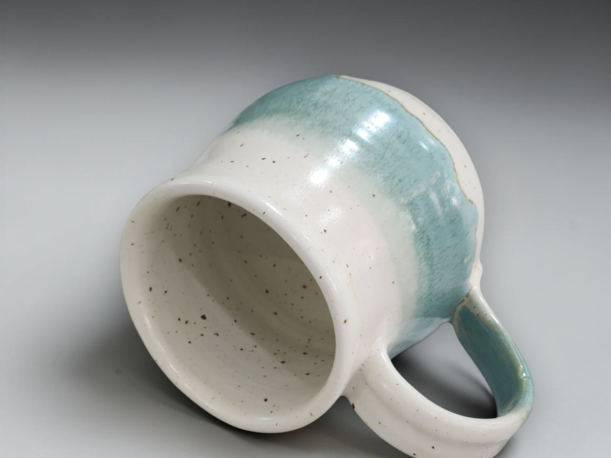 Handmade pottery cup with comfortable handle and rounded form