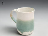 Handmade ceramic mug in cream and soft green glaze