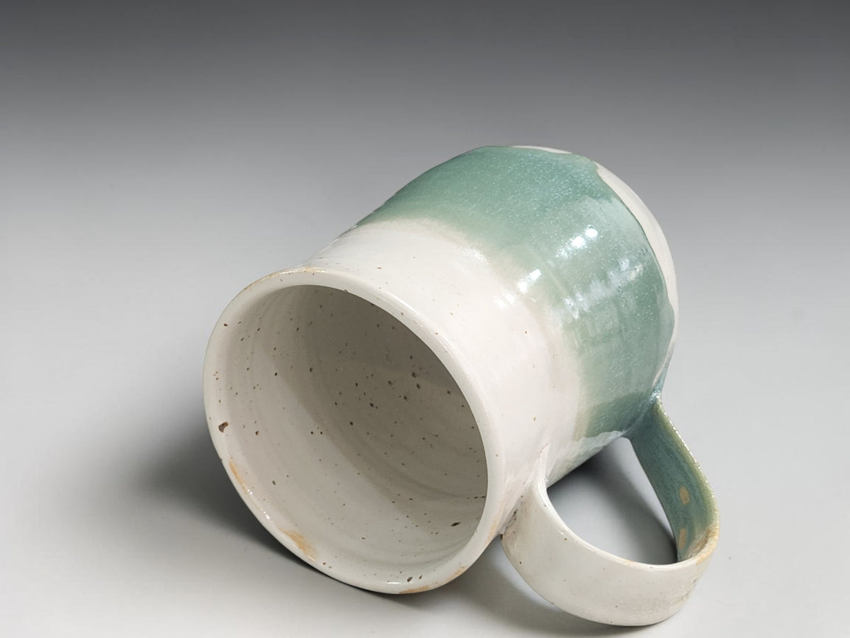 Artisan pottery mug in cream and sage green tones