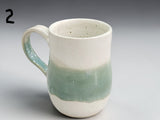 Artisan pottery mug in cream and sage green tones