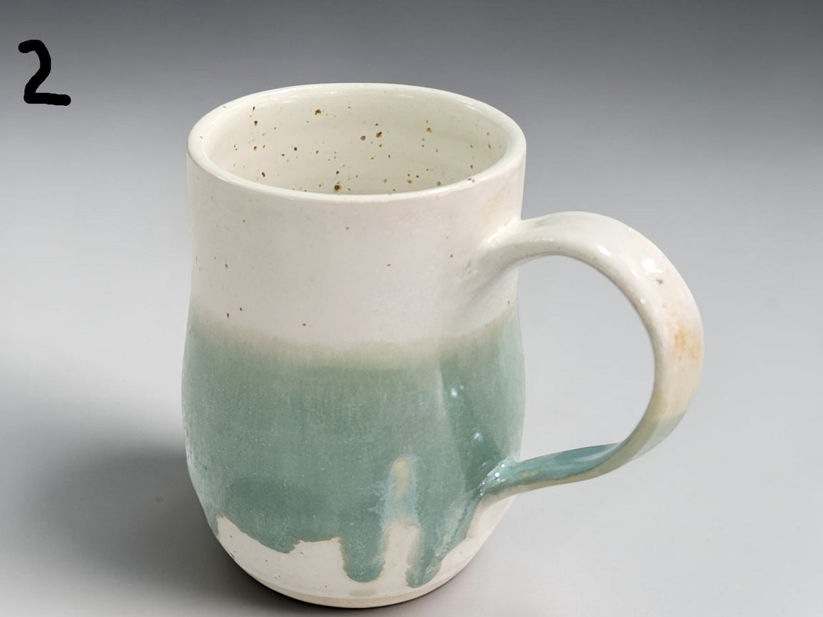 Handmade pottery cup with glossy green glaze detail