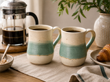 Handmade ceramic mugs by Buxton Pottery in a warm breakfast setting with French press coffee and croissant, featuring a soft green glaze band over speckled stoneware, handcrafted in Melbourne, Australia.