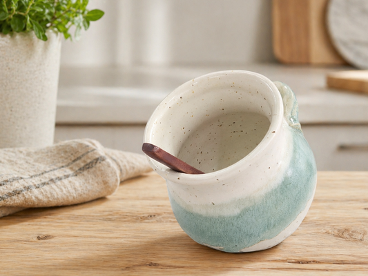 Handmade ceramic salt pig on a light timber kitchen bench in a styled kitchen setting