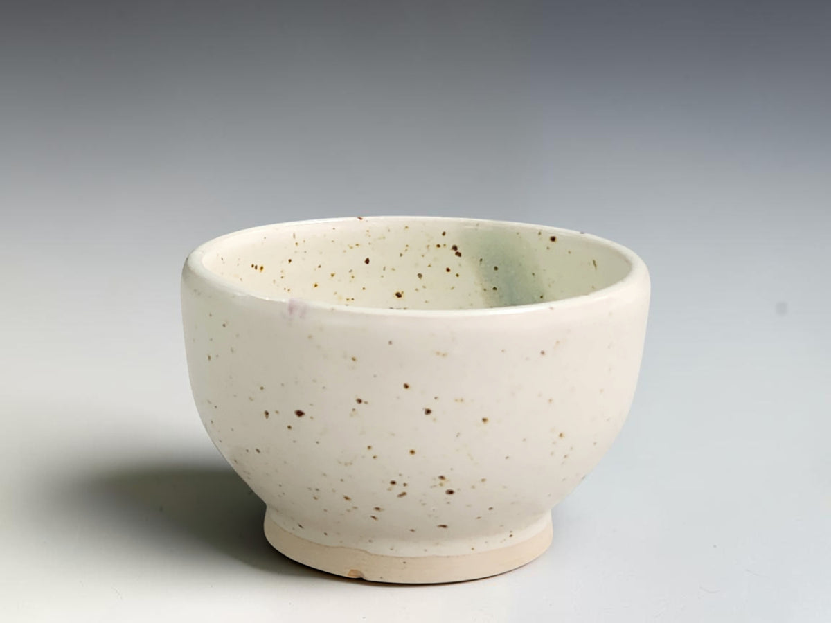 Handmade ceramic condiment bowl by Buxton Pottery with speckled cream glaze and a blue-green interior stripe.