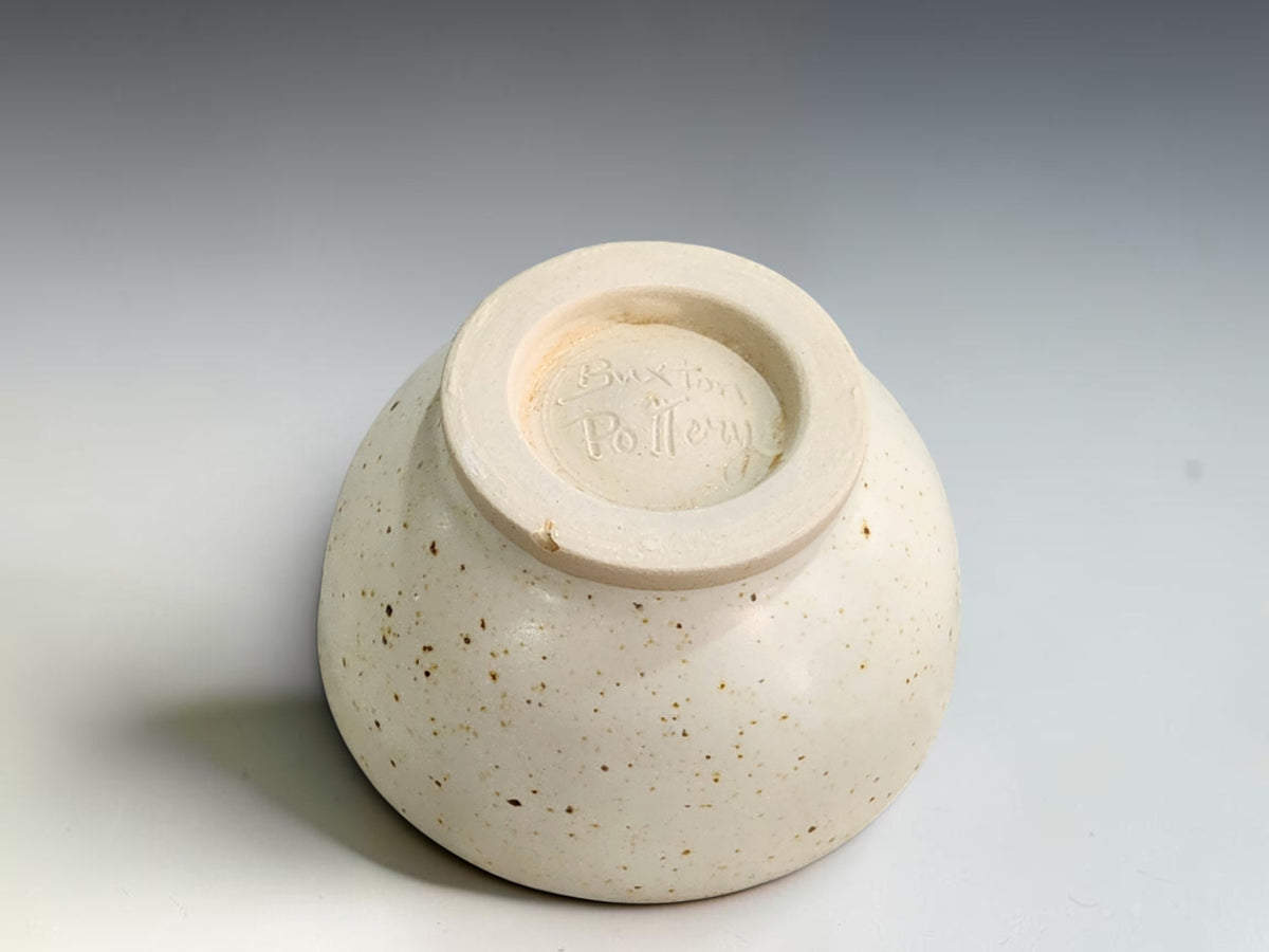Small speckled ceramic condiment bowl with a gently rounded rim and an unglazed cream foot.