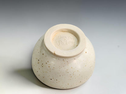 Small speckled ceramic condiment bowl with a gently rounded rim and an unglazed cream foot.