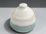 Small ceramic sugar bowl with soft green glaze and speckled cream finish