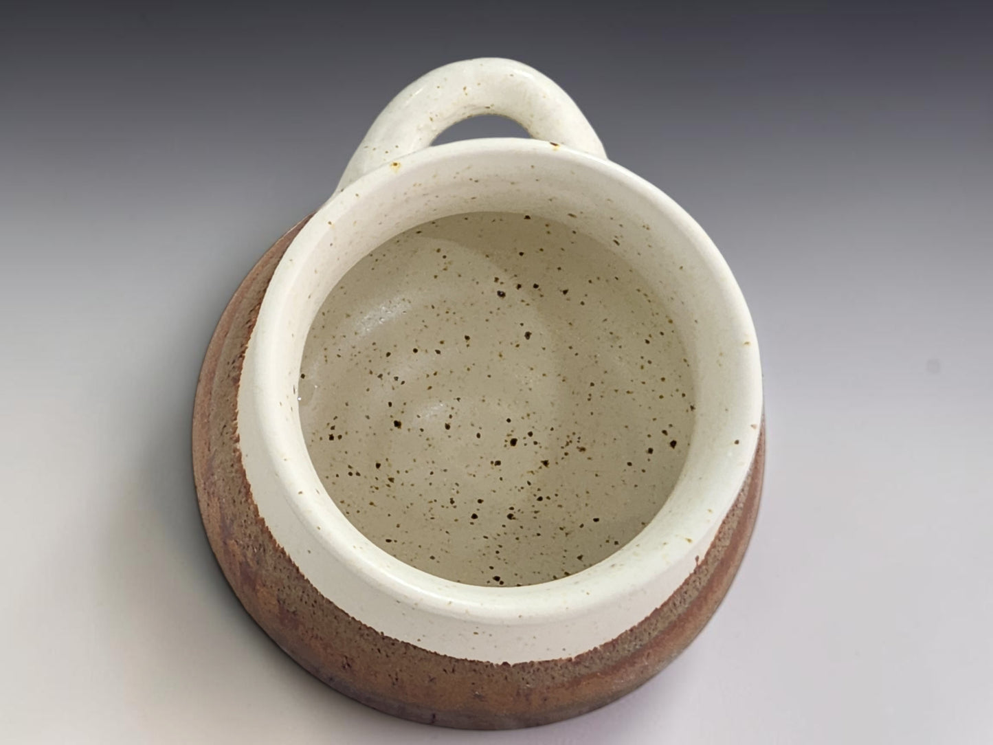 Handmade pottery salt keeper with open front design and rustic two-tone glaze finish