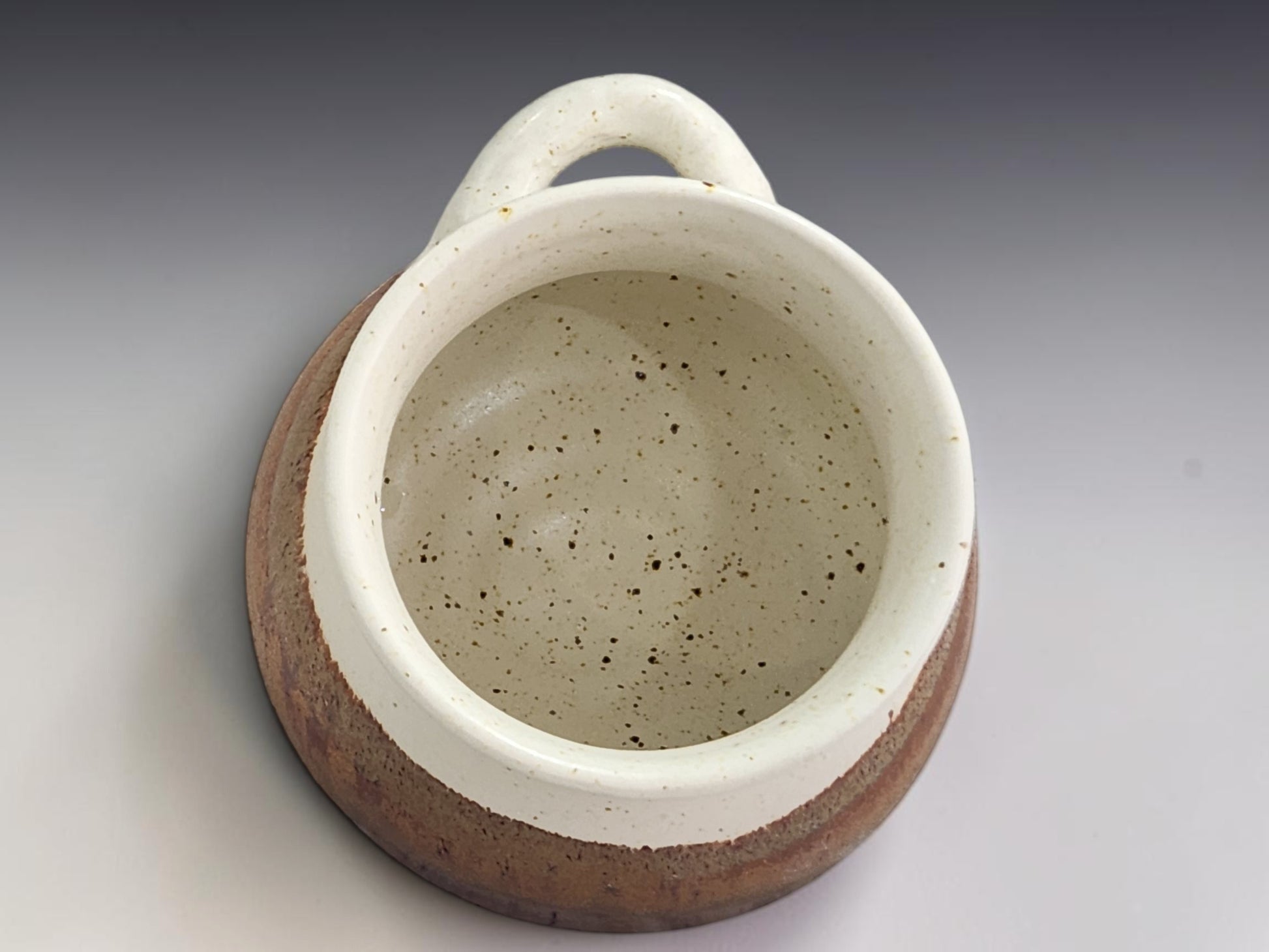 Handmade pottery salt keeper with open front design and rustic two-tone glaze finish