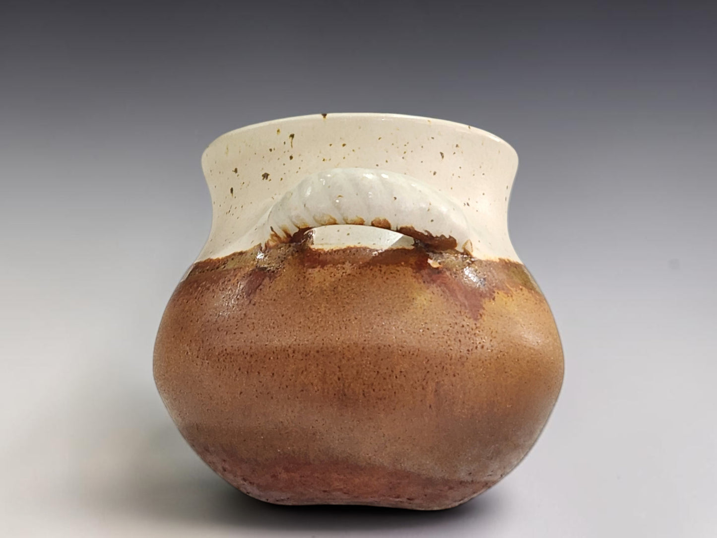 Rustic ceramic salt cellar with spoon in buttermilk cream and terracotta glaze tones