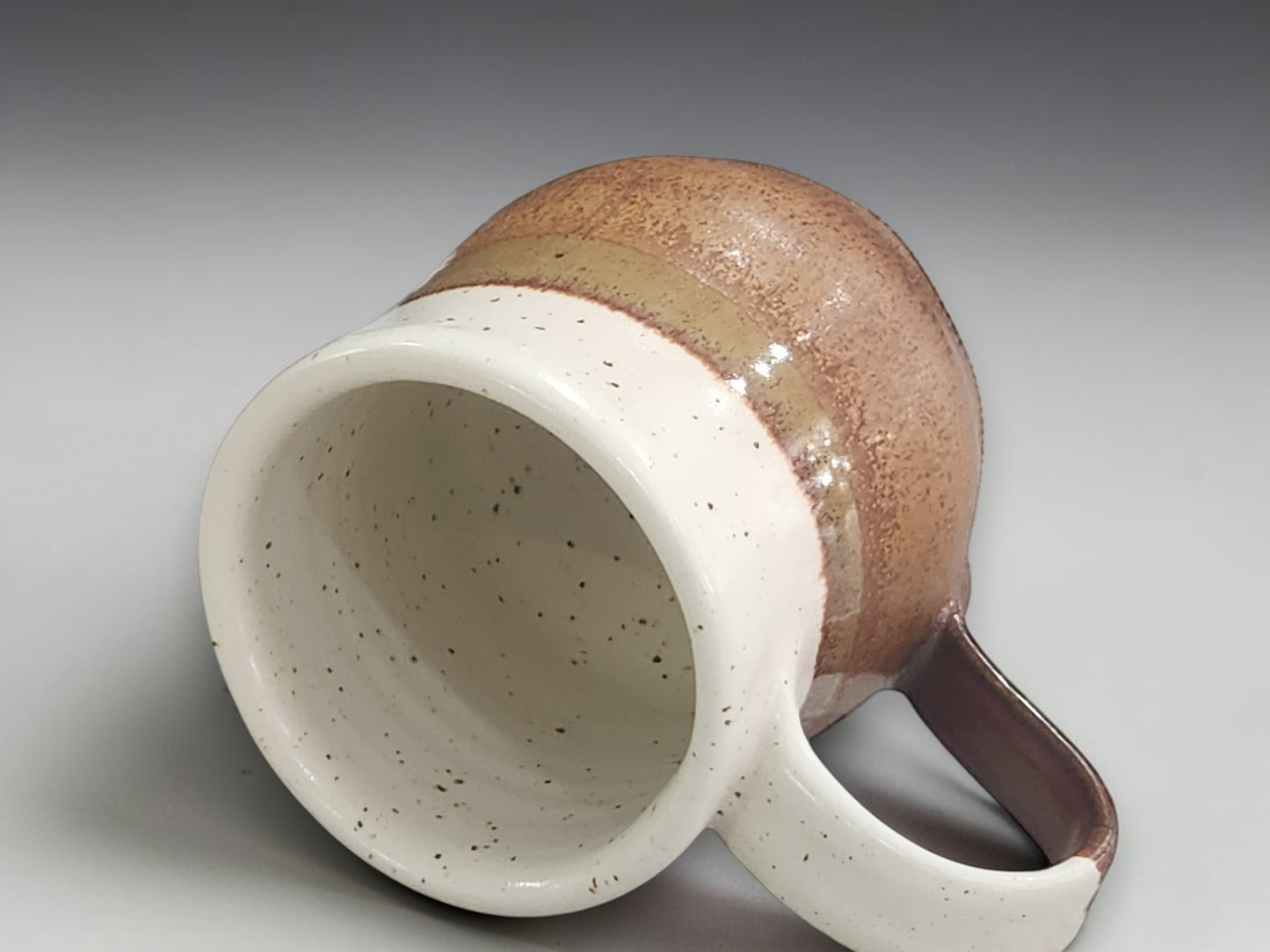 Glossy handmade mug with speckled cream finish