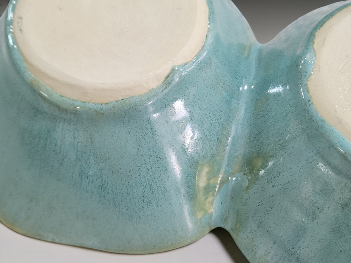 Close up of under side of Aqua glazed pottery snack bowl with organic scalloped shape