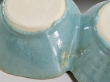 Close up of under side of Aqua glazed pottery snack bowl with organic scalloped shape