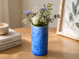 Small blue crystalline vase with a small posey of flowers.