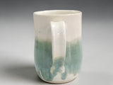 Handmade pottery cup with glossy green glaze detail