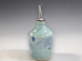 Handmade green ceramic oil bottle with soft blue detail