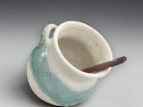 Small pottery salt pig with angled opening and wooden spoon
