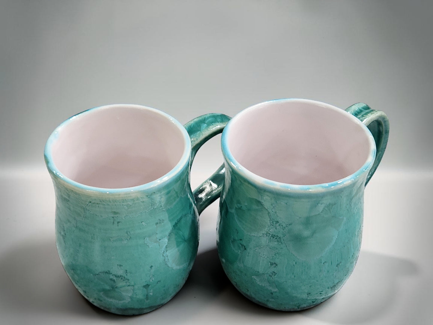 Handmade 350 ml porcelain coffee mug with green crystalline glaze