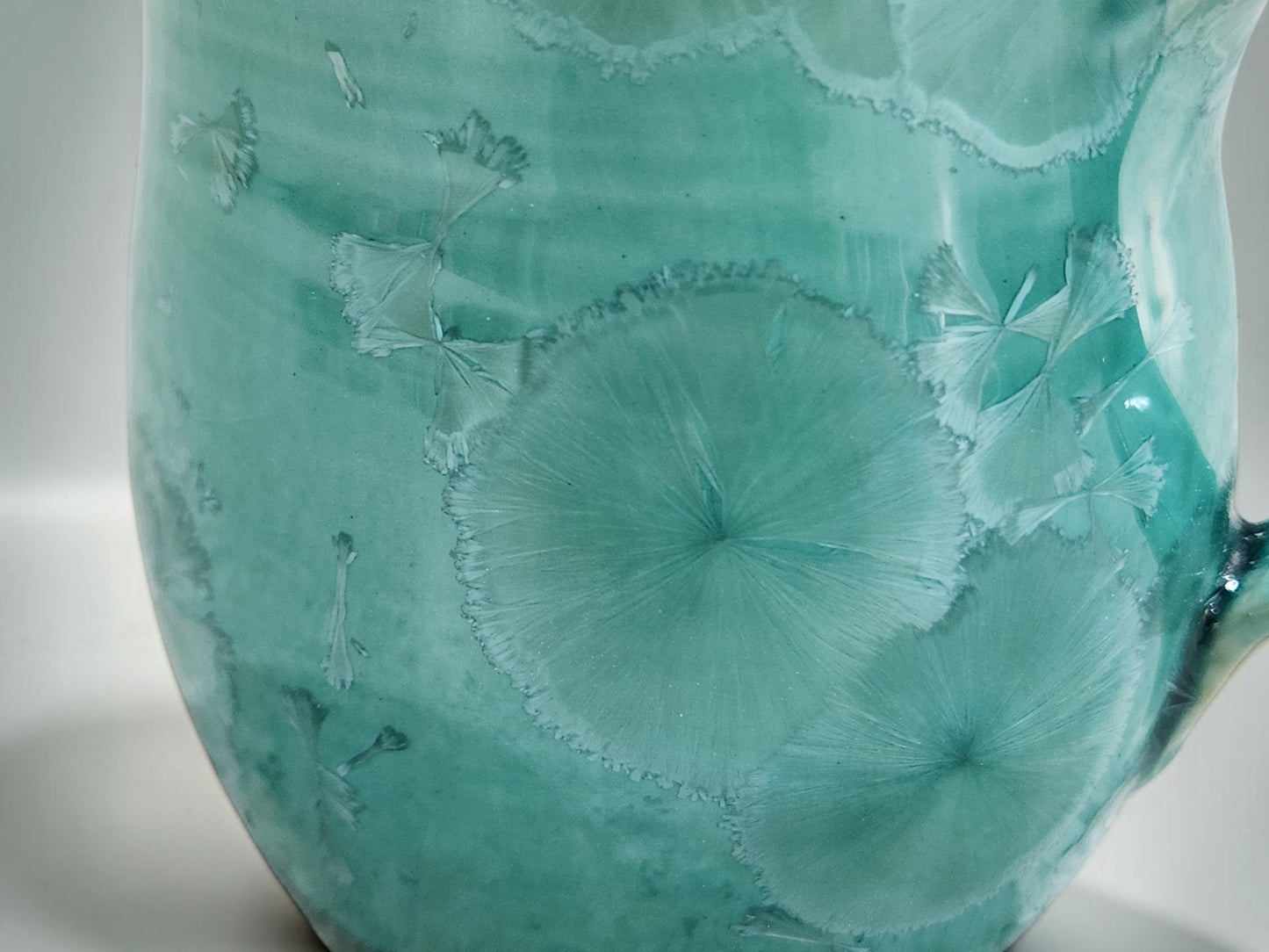 Close-up of naturally formed crystals in a green porcelain glaze
