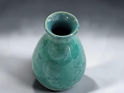 Green pottery vase with rounded body and softly flared opening