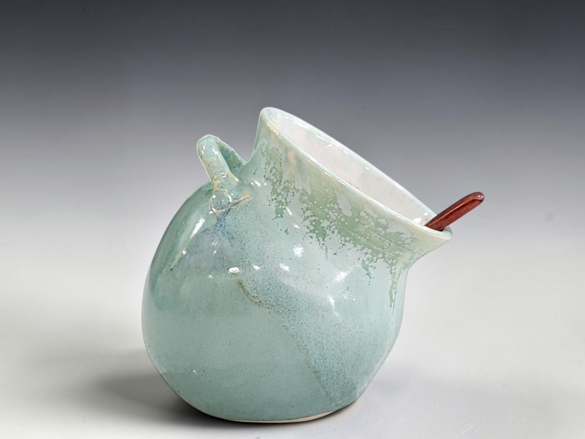 Handmade ceramic salt pig with soft green glaze and wooden spoon