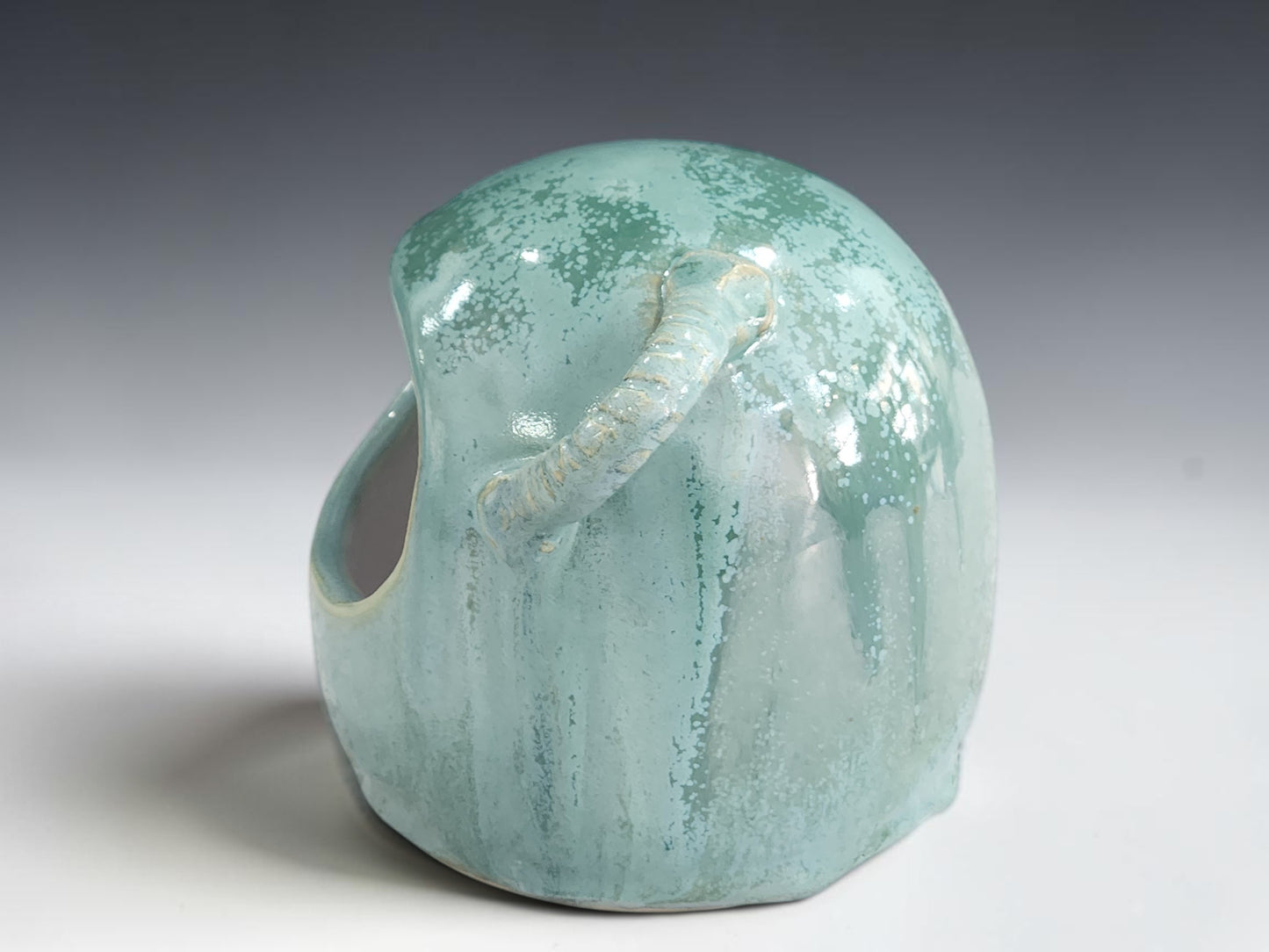 Side view of ceramic salt pig showing handmade loop and wooden spoon