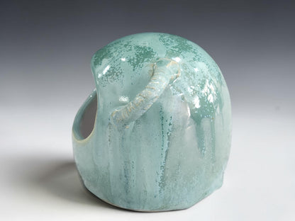 Side view of ceramic salt pig showing handmade loop and wooden spoon