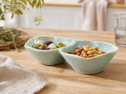 Handmade double snack bowl with olives and nuts in a styled kitchen setting