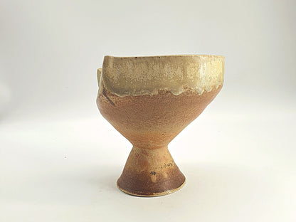 Organic-formed bowl with a slanted, asymmetrical rim and a raised foot.