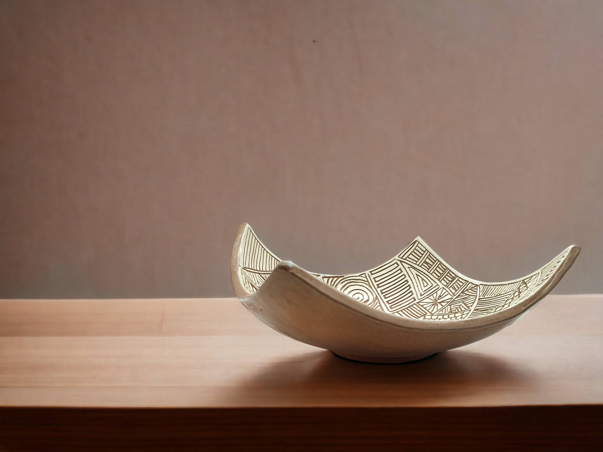 Contemporary drape-style pottery bowl with textured carved linework and organic form