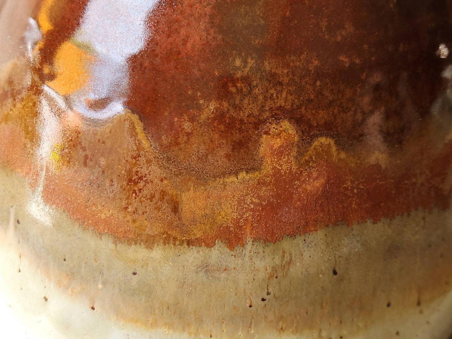 Close up of a Red and cream glazed pottery bowl