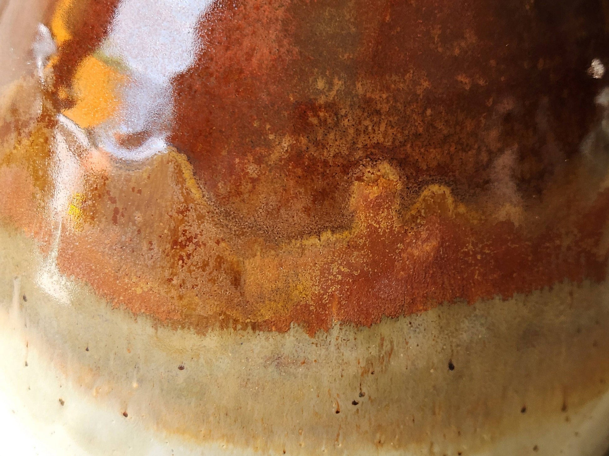 Close up of a Red and cream glazed pottery bowl