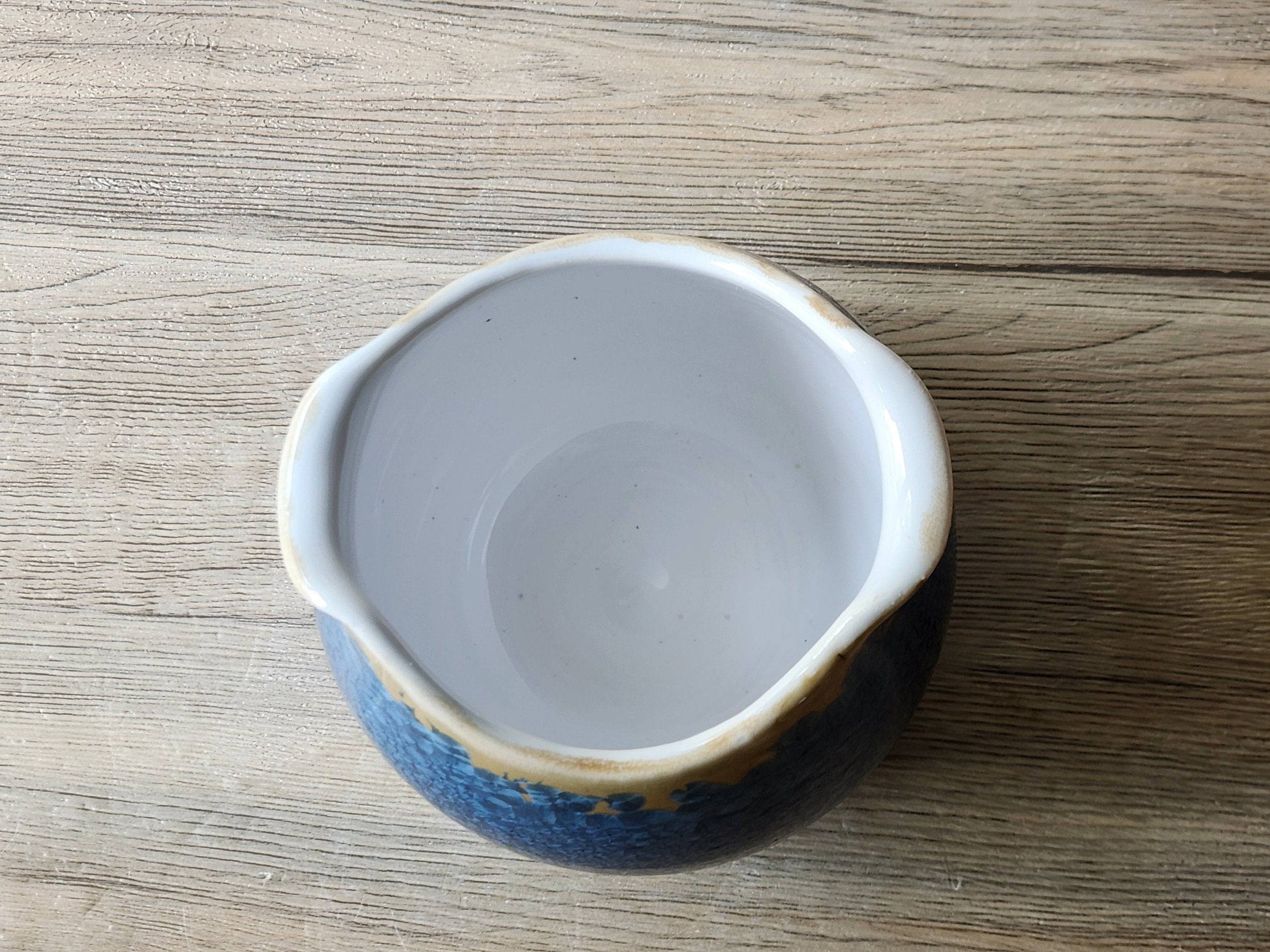 Ceramic entryway display bowl with blue and orange crystals and whte lining