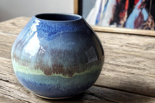 Handmade ceramic moon jar on wooden table