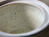 Close up of specked cream glaze on the inside of the handmade ceramic lidded pot.