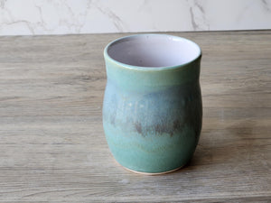 Functional stoneware coffee mug with ocean-inspired glaze and white lining