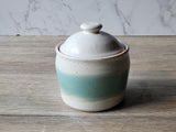 A handmade pottery sugar bowl in soft speckled cream with a vertical panel of spearmint green. Beautiful and functional pottery.