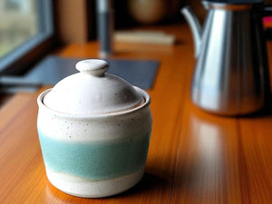 A handmade ceramic jar glazed in soft speckled cream with a vertical panel of spearmint green. Beautiful and functional pottery.