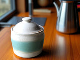 A handmade ceramic jar glazed in soft speckled cream with a vertical panel of spearmint green. Beautiful and functional pottery.