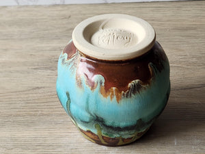 Underside of Unique pottery tea cup with mottled turquoise and moss green glazes