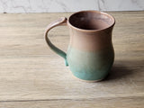 Artisan handmade mug with oatmeal brown interior and green base
