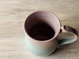 Handmade ceramic coffee mug with earthy brown and spearmint tones