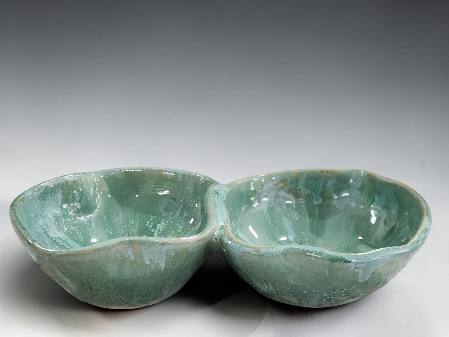 Mottled green ceramic divided bowl handcrafted in Melbourne, showcasing unique glaze movement and artisan craftsmanship.