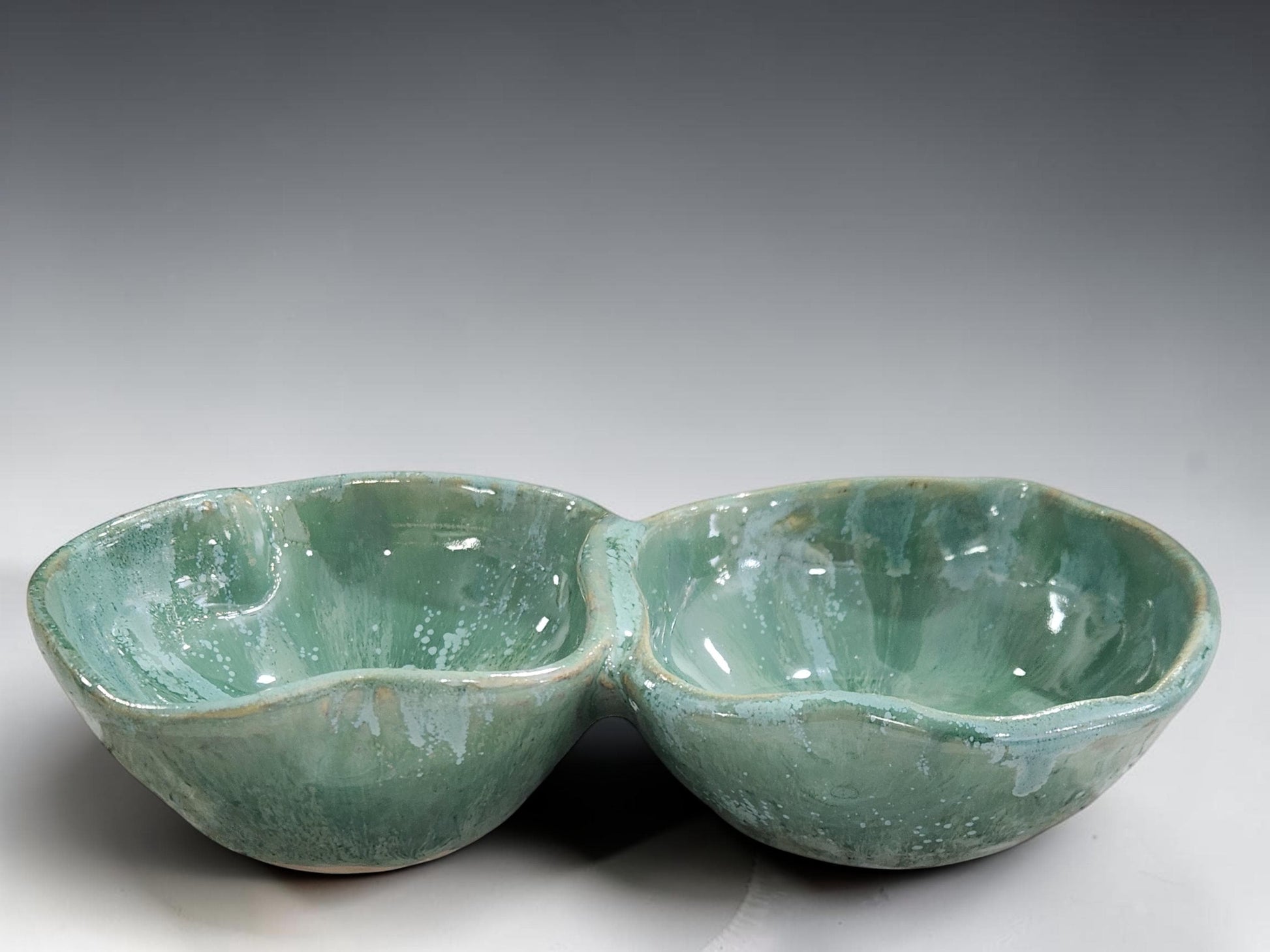 Mottled green ceramic divided bowl handcrafted in Melbourne, showcasing unique glaze movement and artisan craftsmanship.